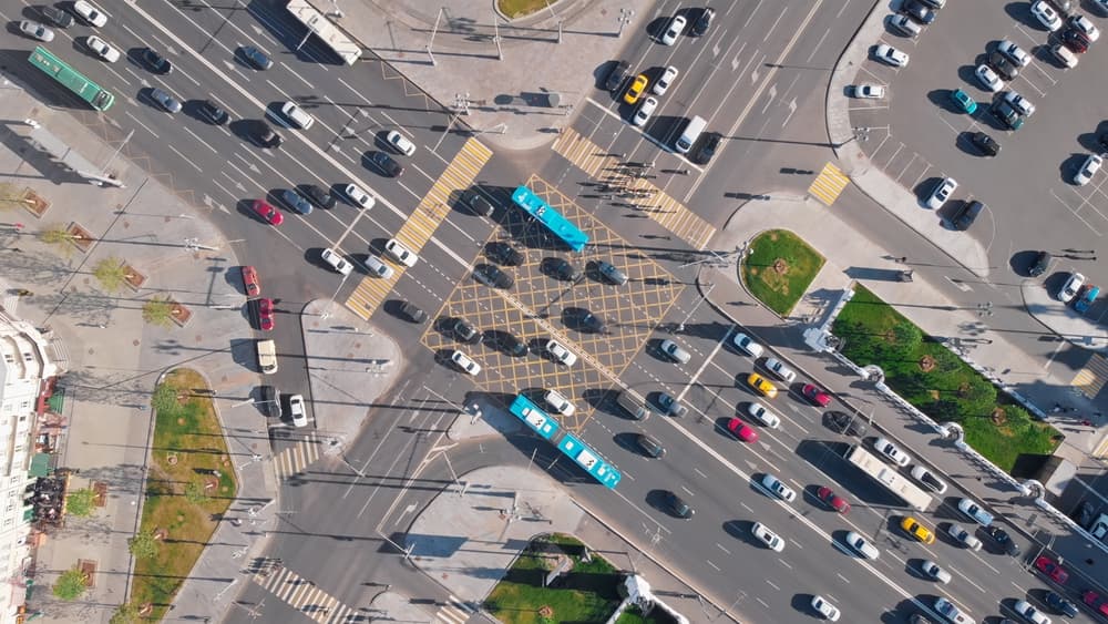 Aerial view of a busy intersection with various vehicles crossing in multiple directions.