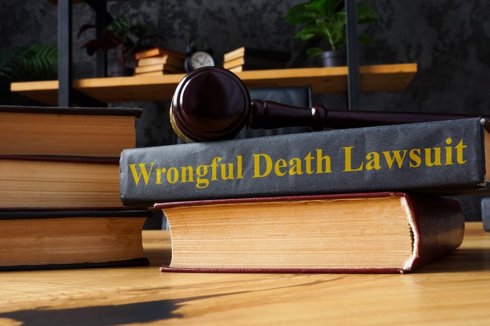 Books on law and a gavel, with "Wrongful Death Lawsuit" visible on spine, on desk.
