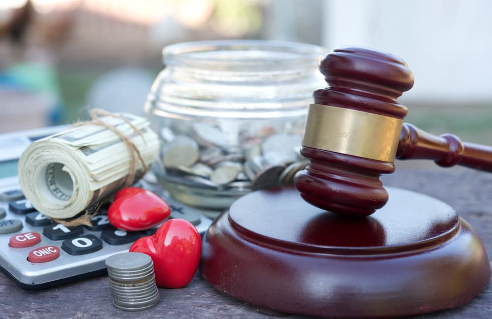 Gavel, calculator, money, and heart-shaped objects symbolizing the costs and emotions in personal injury cases.