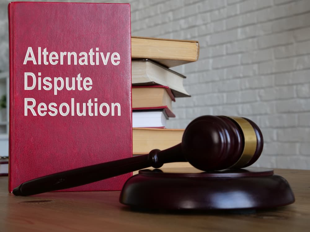 The phrase "Alternative Dispute Resolution (ADR)" is displayed in a conceptual business image, emphasizing the idea of resolving disputes outside of court.