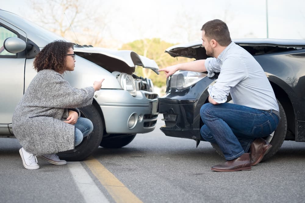 Man and woman engaged in a heated argument following a serious car accident.






