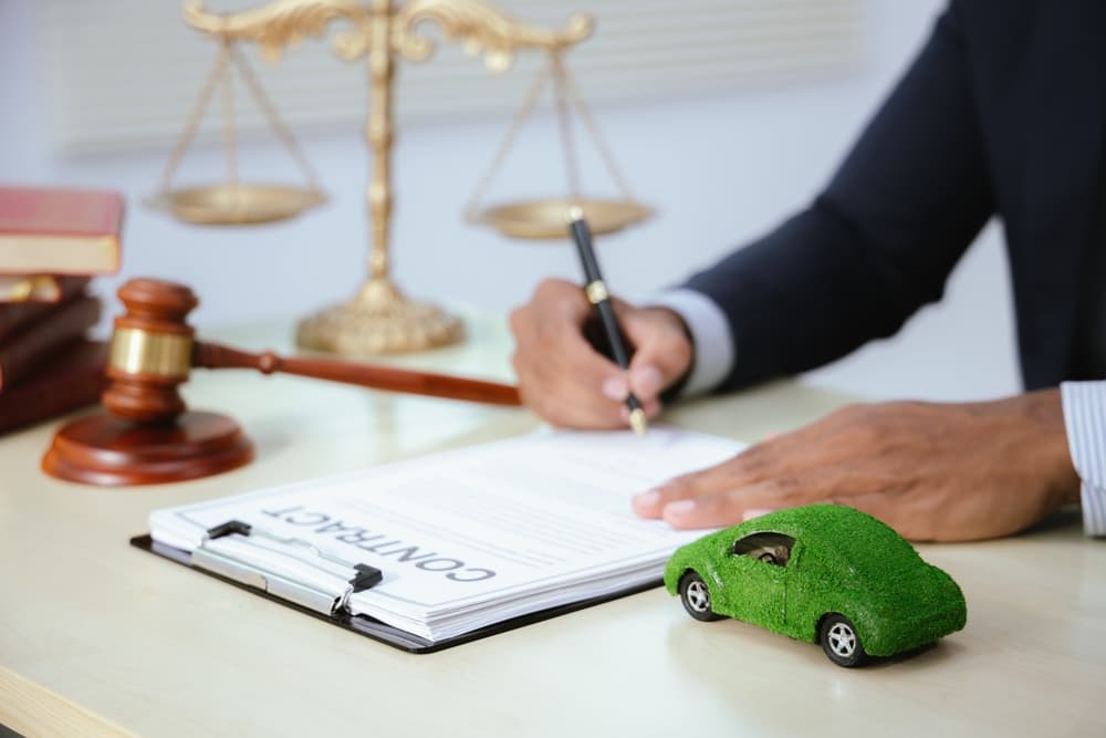 In a courtroom, a judge presides over a car accident case, holding a gavel. Lawyers present evidence and legal documents, with the outcome set to influence insurance claims and underscore the legal system's importance.