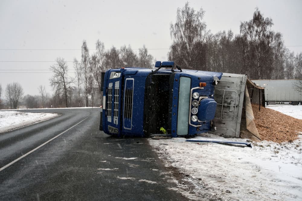 A truck carrying sawdust overturned on the slick roadway.